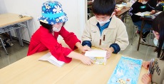 屏風の折り方をA君に教えてくれるSちゃん