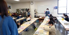 先生が紙粘土の仕上げの説明中